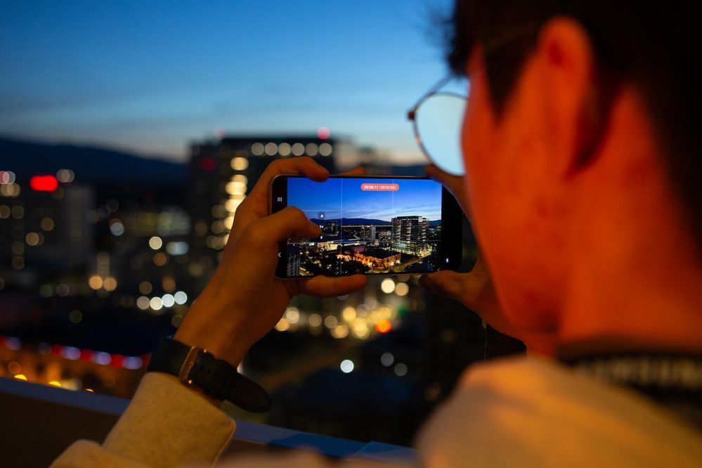 A man taking a photo of a city with an S24 Series device.jpg